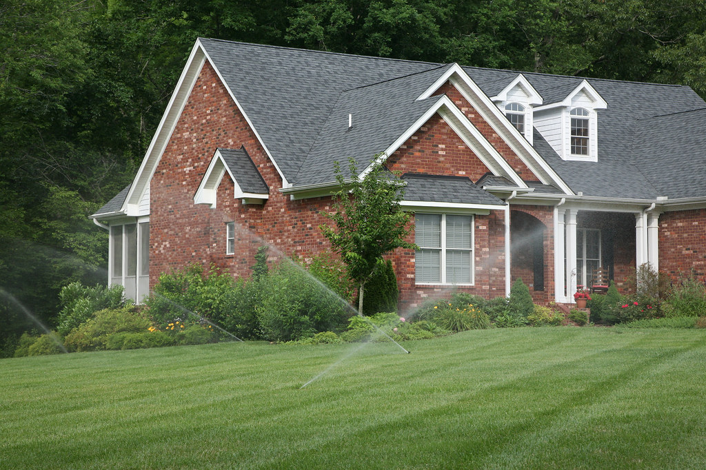 Residential lawn irrigation system running across grass